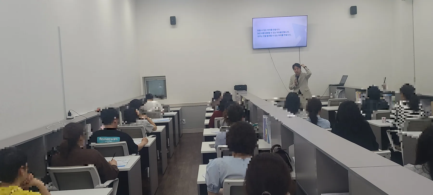 설명회 강의실 전체. 학부모들이 자리에 앉아 화면을 보고 있다